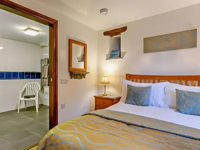 a bedroom with a bed and a chair in it at 4 Bed in Boscastle oc-47035 in Boscastle