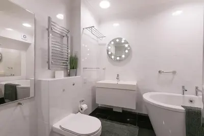 a white bathroom with a toilet and a sink at Ocean Edge in St Ives