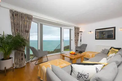 a living room with a couch and a large window at Ocean Edge in St Ives