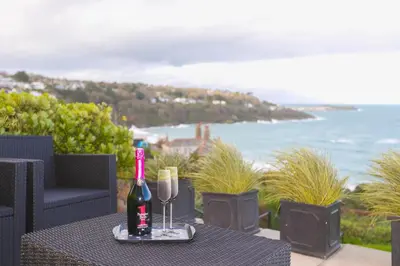 a table with a bottle of wine and two glasses at Ocean Edge in St Ives