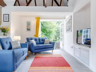 a living room with two blue couches and a red rug at 2 Bed in Penryn oc-78621 in Penryn
