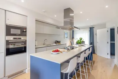 a kitchen with a large island with bar stools at 2 Bed in Harlyn Bay oc-a28321 in St Merryn