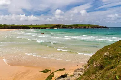a beach with people swimming in the ocean at 2 Bed in Harlyn Bay oc-a28321 in St Merryn