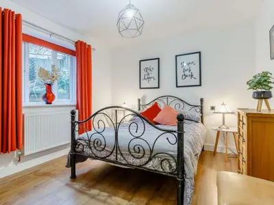 a bedroom with a bed with orange pillows on it at 2 Bed in Redruth oc-86269 in Gwennap