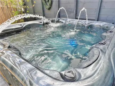 a hot tub with a water fountain in a backyard at 2 Bed in Redruth oc-86269 in Gwennap