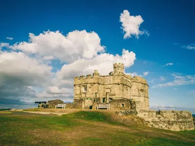 an old castle on a grassy hill with a blue sky at 2 Bed in Redruth oc-86269 in Gwennap