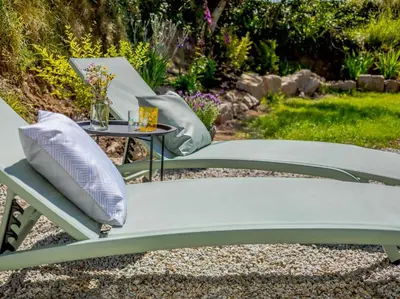 a patio chair with pillows and a table at 3 Bed in Redruth oc-88102 in Redruth
