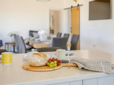 a cutting board with a loaf of bread and fruit on a counter at 3 Bed in Redruth oc-88102 in Redruth