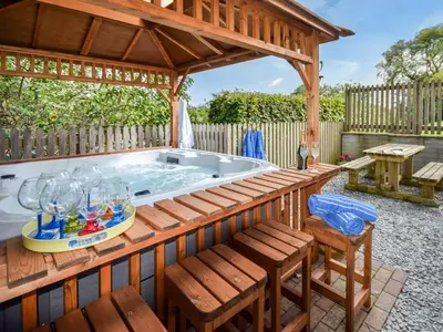 a hot tub in a pavilion with a table and chairs at 2 Bed in Truro oc-ljasm in Saint Allen