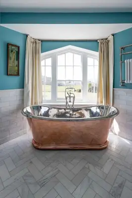 a large tub in a room with a window at Catchfrench Manor in Sheviock
