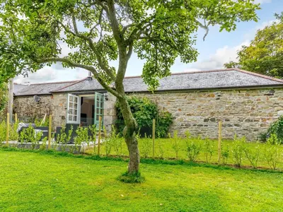 a stone cottage with a tree in front of it at 2 Bed in Penryn oc-78620 in Penryn