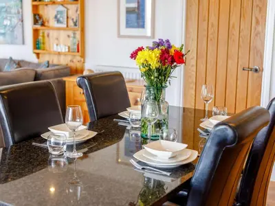 a table with chairs and a vase of flowers on it at 2 Bed in Redruth oc-sanap in Portreath