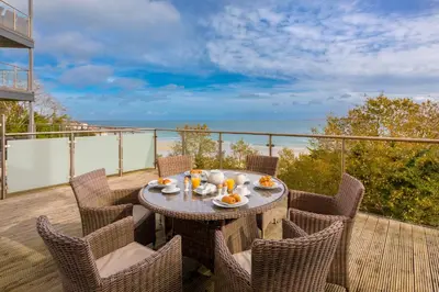 a table and chairs on a balcony with a view of the ocean at Number One Peninsula in St Ives