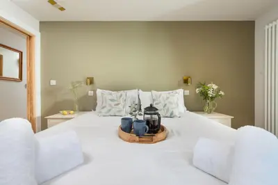a bedroom with a white bed with two chairs at Beachside in Newquay
