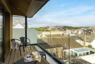 a balcony with a table and chairs and a view at Beachside in Newquay