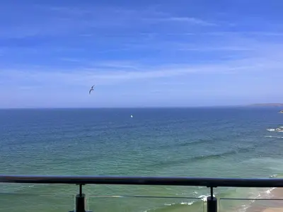 a bird flying in the sky over the ocean at Newquay Rocklands Beach View in Newquay