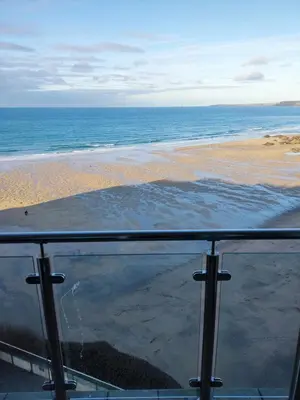 a view of the beach from a glass balcony at Newquay Rocklands Beach View in Newquay