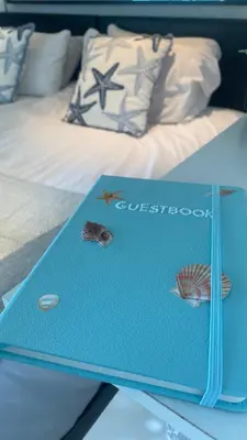 a blue book sitting on top of a bed at Newquay Rocklands Beach View in Newquay