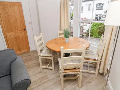 a dining room with a wooden table and chairs at Kelsey in Truro