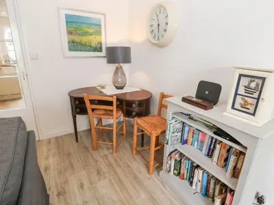 a living room with a desk and a table with a laptop at Kelsey in Truro