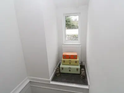 a corner of a room with two suitcases in front of a window at Kelsey in Truro