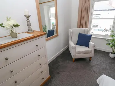 a bedroom with a dresser and a chair and a mirror at Kelsey in Truro