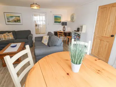 a living room with a table and a couch at Kelsey in Truro