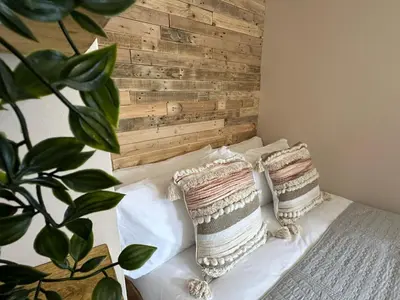 a bedroom with a wooden headboard and pillows on a bed at Aggie Beach Apartment - Unrivalled Beach Views in St. Agnes