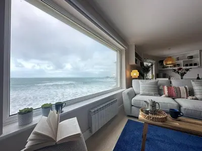 a living room with a large window overlooking the ocean at Aggie Beach Apartment - Unrivalled Beach Views in St. Agnes