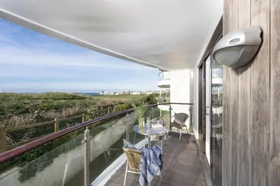 a balcony with a table and chairs and a view of the ocean at 10 Bredon Court - Close to Town & Beaches - Free Parking & WiFi - Sea View in Newquay
