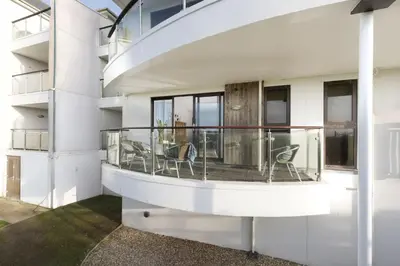 a balcony with chairs and a table on a building at 10 Bredon Court - Close to Town & Beaches - Free Parking & WiFi - Sea View in Newquay
