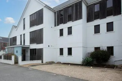 a white building with black windows at 10 Bredon Court - Close to Town & Beaches - Free Parking & WiFi - Sea View in Newquay