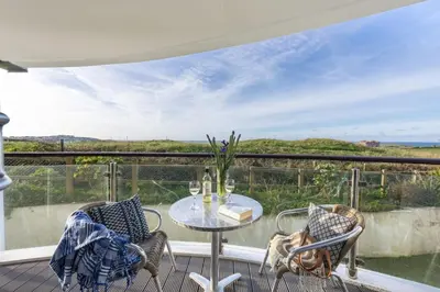 a patio with a table and chairs on a balcony at 10 Bredon Court - Close to Town & Beaches - Free Parking & WiFi - Sea View in Newquay