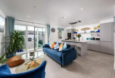 a living room with a blue couch and a table at 1 Cliff Edge in Newquay in Newquay