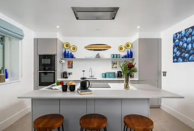 a kitchen with a counter and two stools at 1 Cliff Edge in Newquay in Newquay