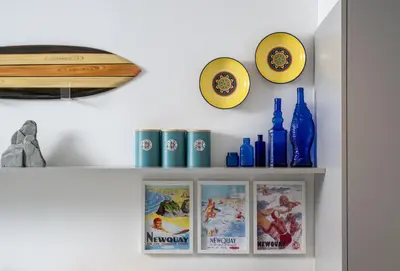 a shelf with blue and yellow plates and bottles at 1 Cliff Edge in Newquay in Newquay