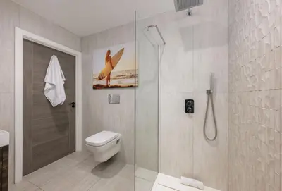 a bathroom with a shower and a toilet and a glass shower at 1 Cliff Edge in Newquay in Newquay