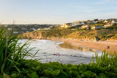 a beach with a group of people in the water at 1 Cliff Edge in Newquay in Newquay