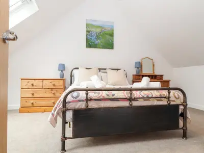 a bedroom with a bed and a painting on the wall at Wildwood in Newquay