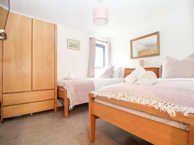 a bedroom with two beds and a mirror at Wildwood in Newquay