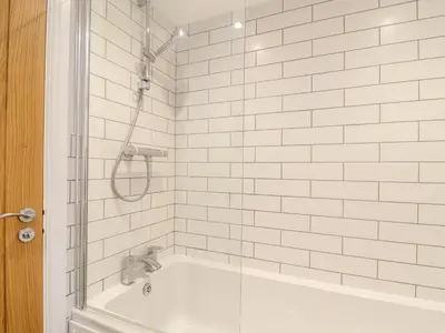 a bathroom with a shower and a bath tub with a shower at Wildwood in Newquay