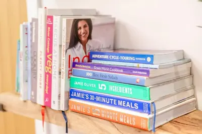 a stack of books sitting on a shelf at Luxury holiday home near the coast in Porthtowan