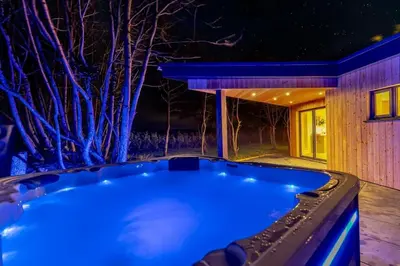 a hot tub in a backyard at night at Luxury holiday home near the coast in Porthtowan