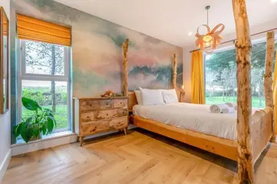 a bedroom with a bed and a large window at Luxury holiday home near the coast in Porthtowan
