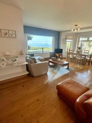 a living room with a couch and a table at The Surf House (Widemouth Bay) in Bude