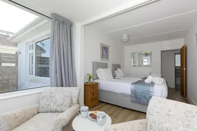 a bedroom with a bed and a couch and a table at Ocean Aura in Carbis Bay