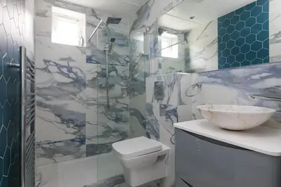 a bathroom with a white toilet and a sink at Ocean Aura in Carbis Bay