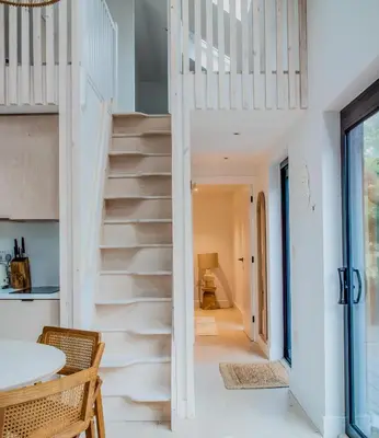 a staircase in a home with white walls and ceilings at Lowen Tree House in Truro