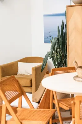 a living room with a couch and a table and chairs at Lowen Tree House in Truro
