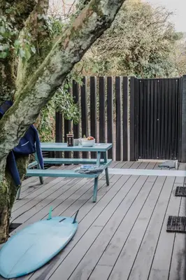 a picnic table on a deck with a tree at Lowen Tree House in Truro